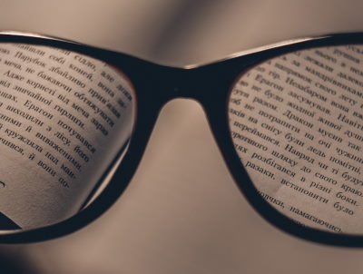 A pair of spectacles magnifying some text